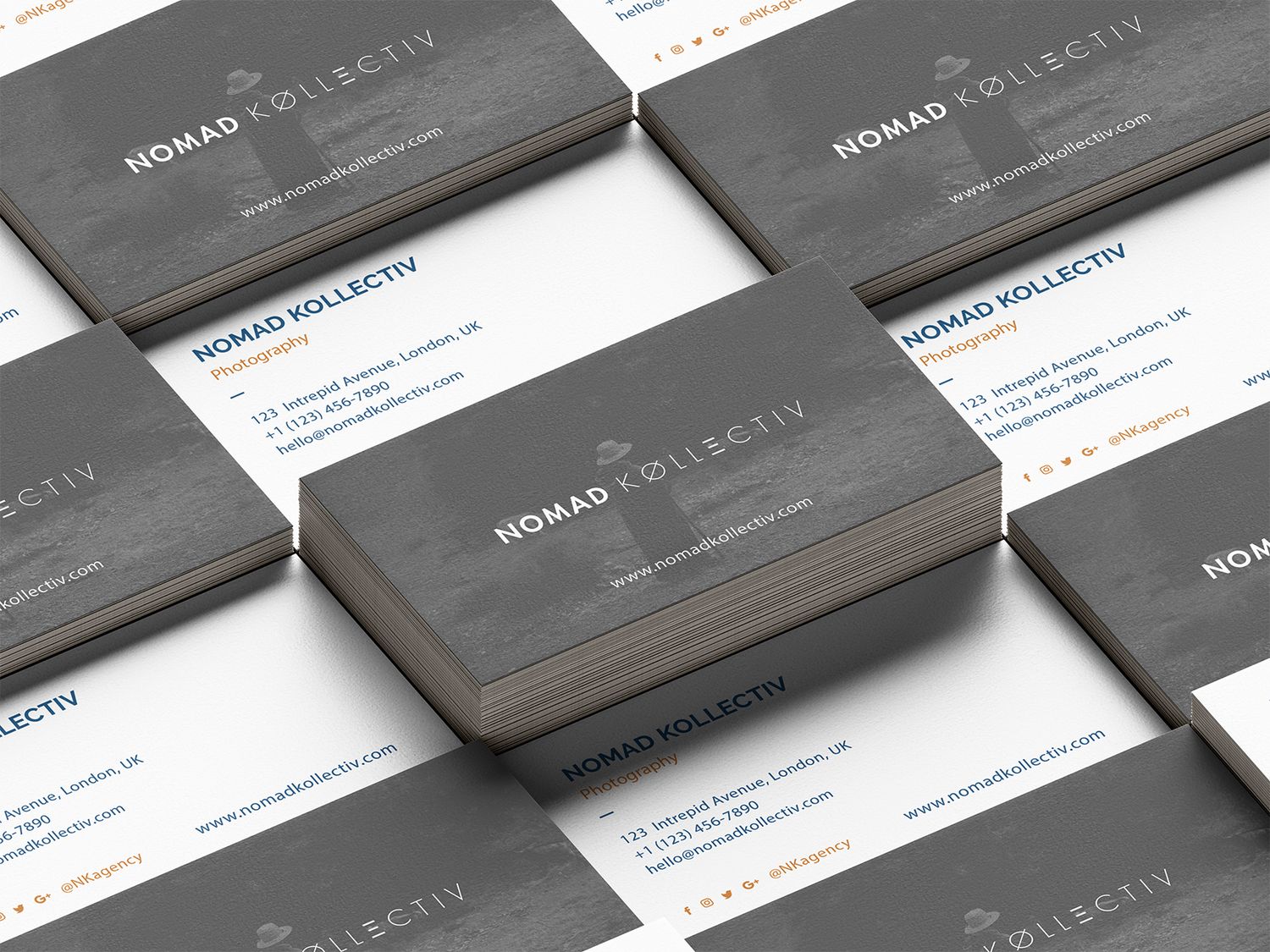 Stack of elegant gray business cards for Nomad Kollectiv arranged in a professional flat lay display.