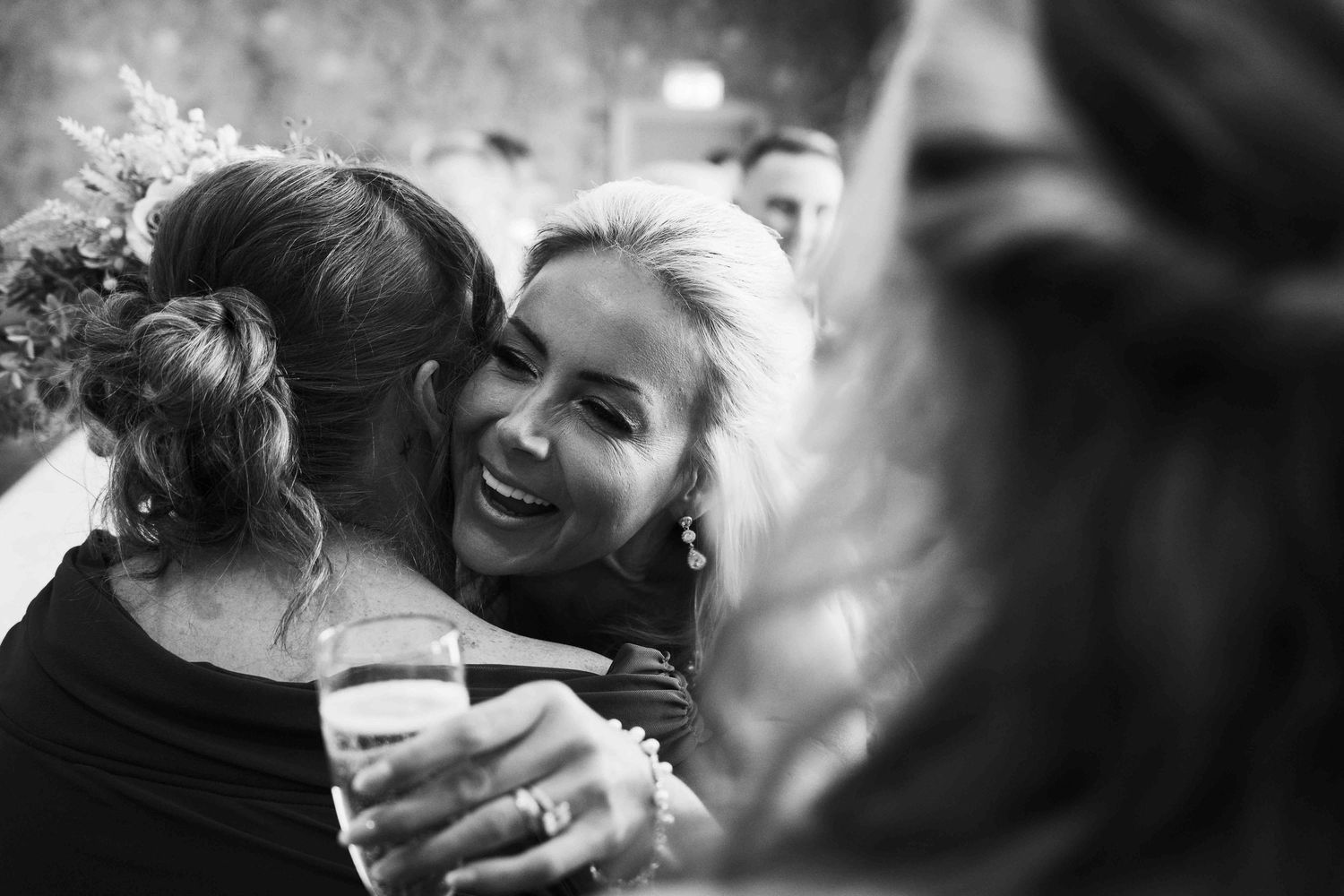 Black and white photo of two women sharing a warm embrace at a wedding reception. Irish wedding photography. Dunboyne Castle