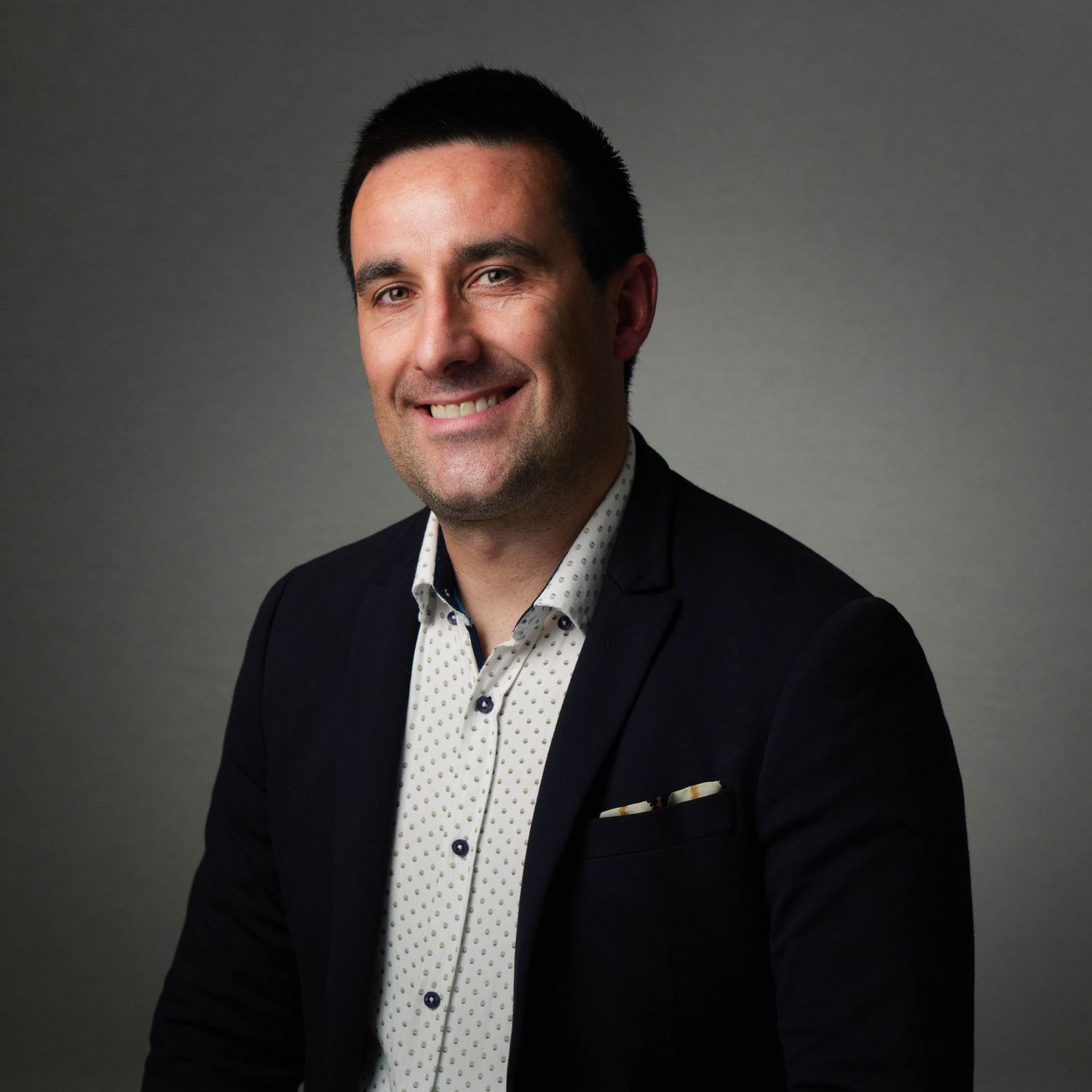 Confident smiling businessman in navy blazer posing for professional corporate headshot portrait. Headshot Photography Ireland