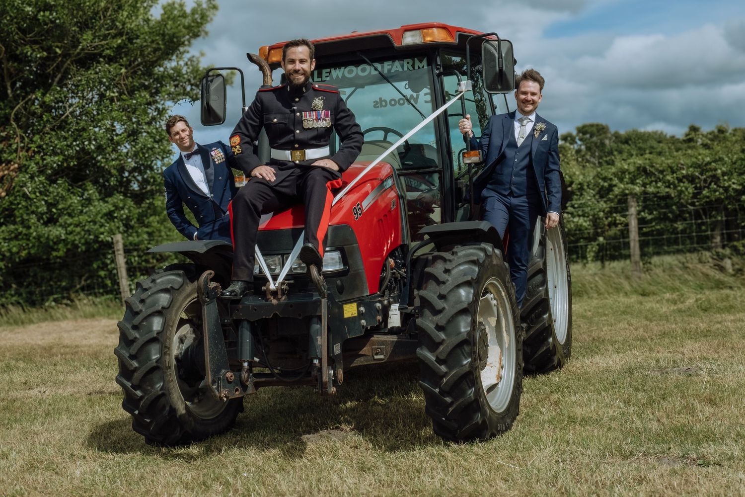 Groom with his groomsmen posing on a tractor,.