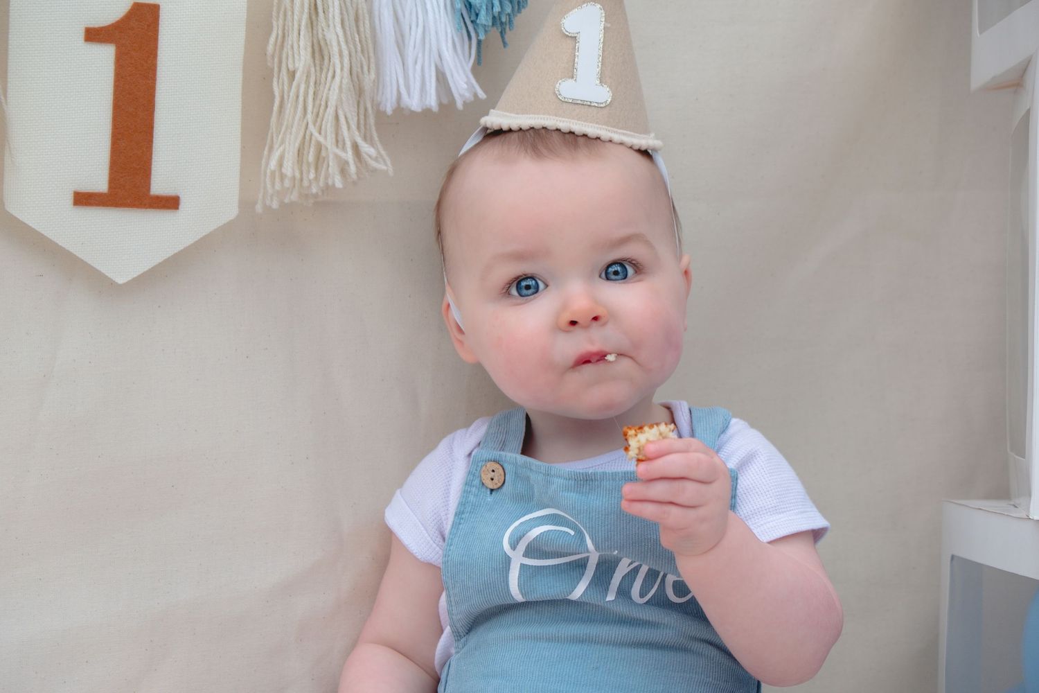 Little boy enjoying his first birthday cake smash photoshoot.