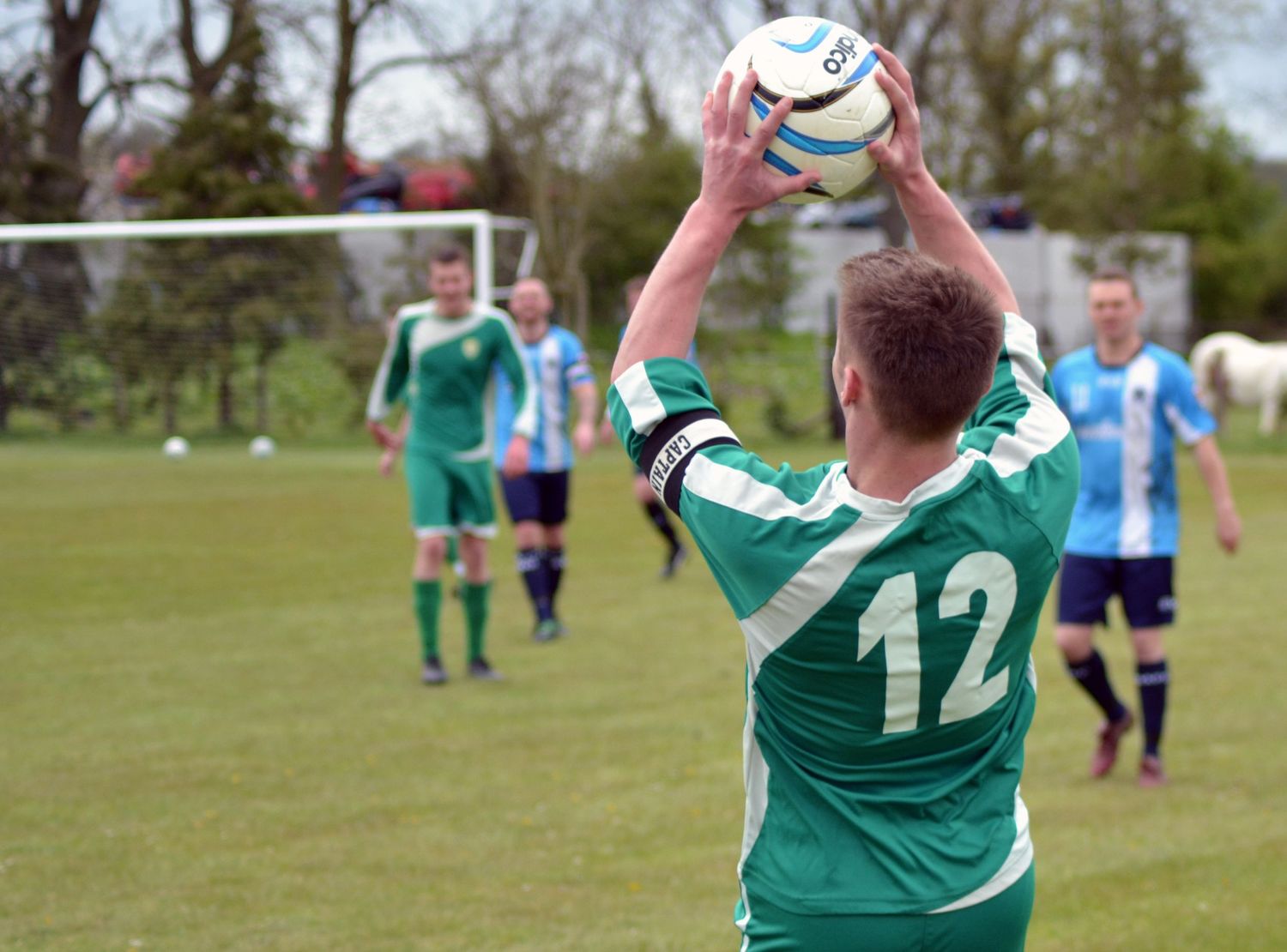 Offside so many in green football shirt, player number 12, about the throw the football back in.