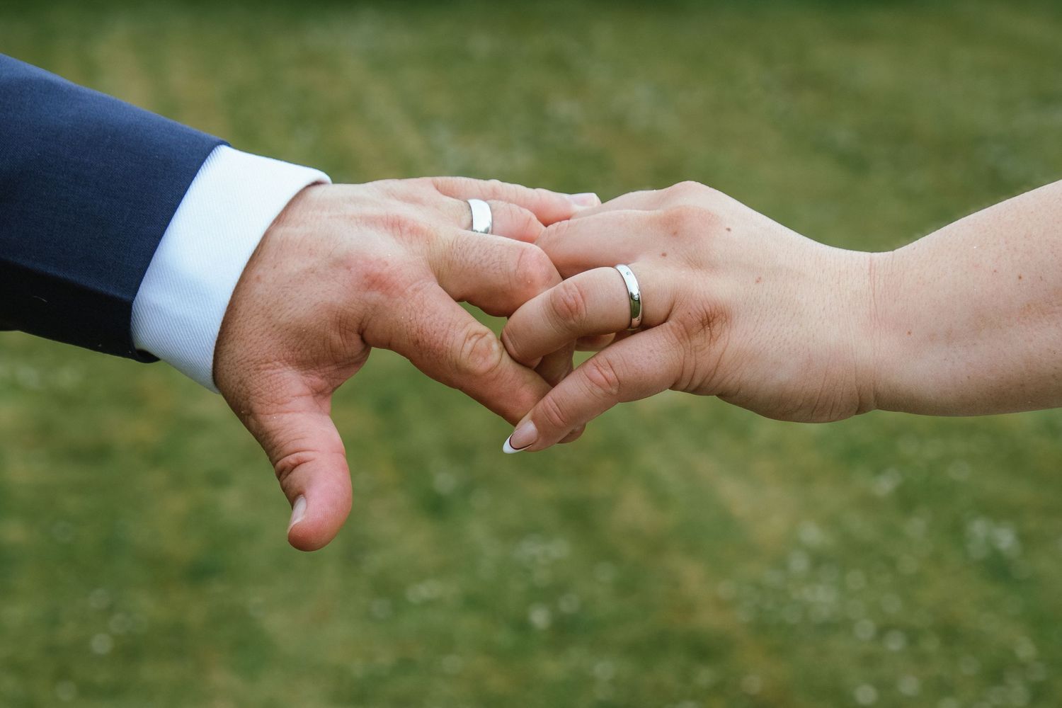 Newly married couple walking hand in hand through the countryside.