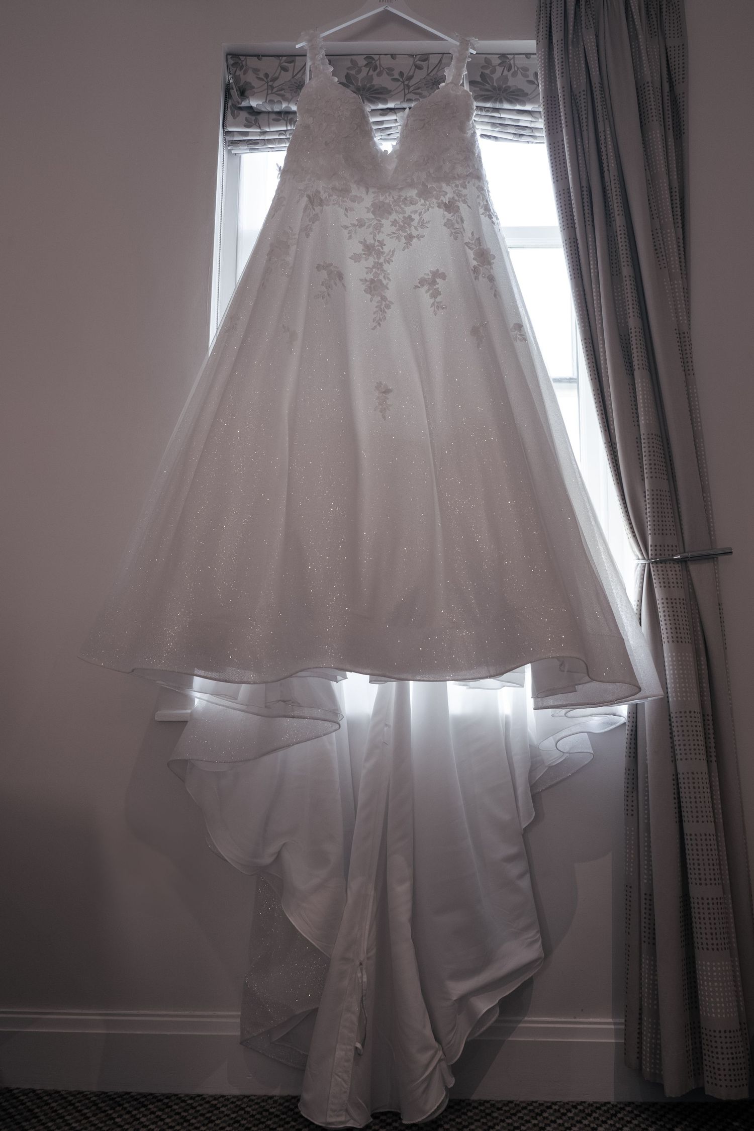 Shot of the the bride's wedding dress hung up ready to be put on.