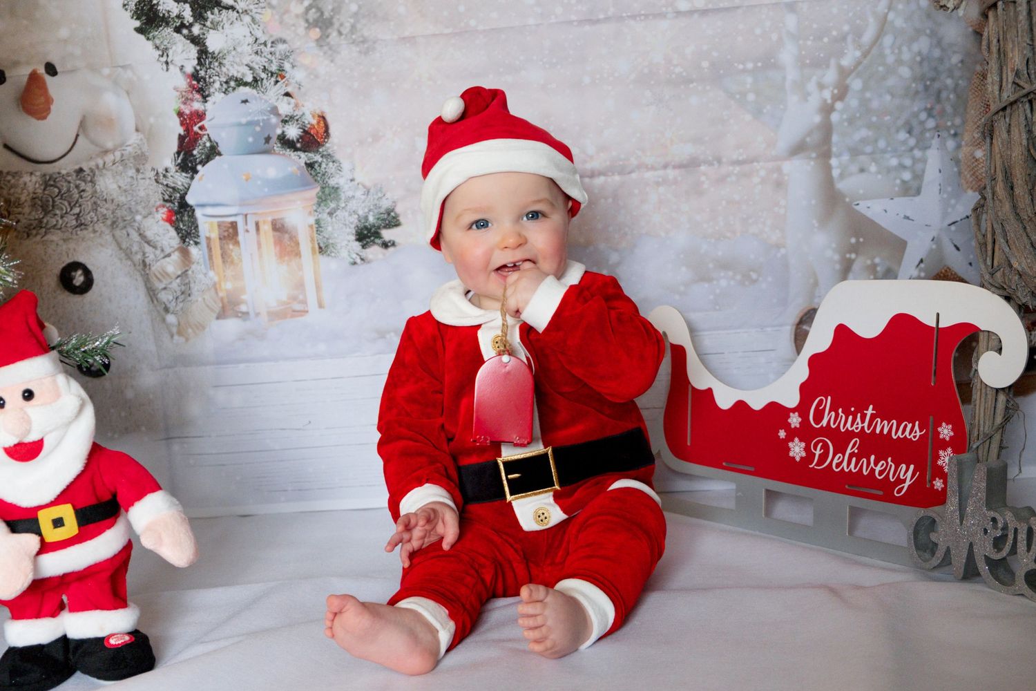 Young child smiling during a Christmas-themed photoshoot.