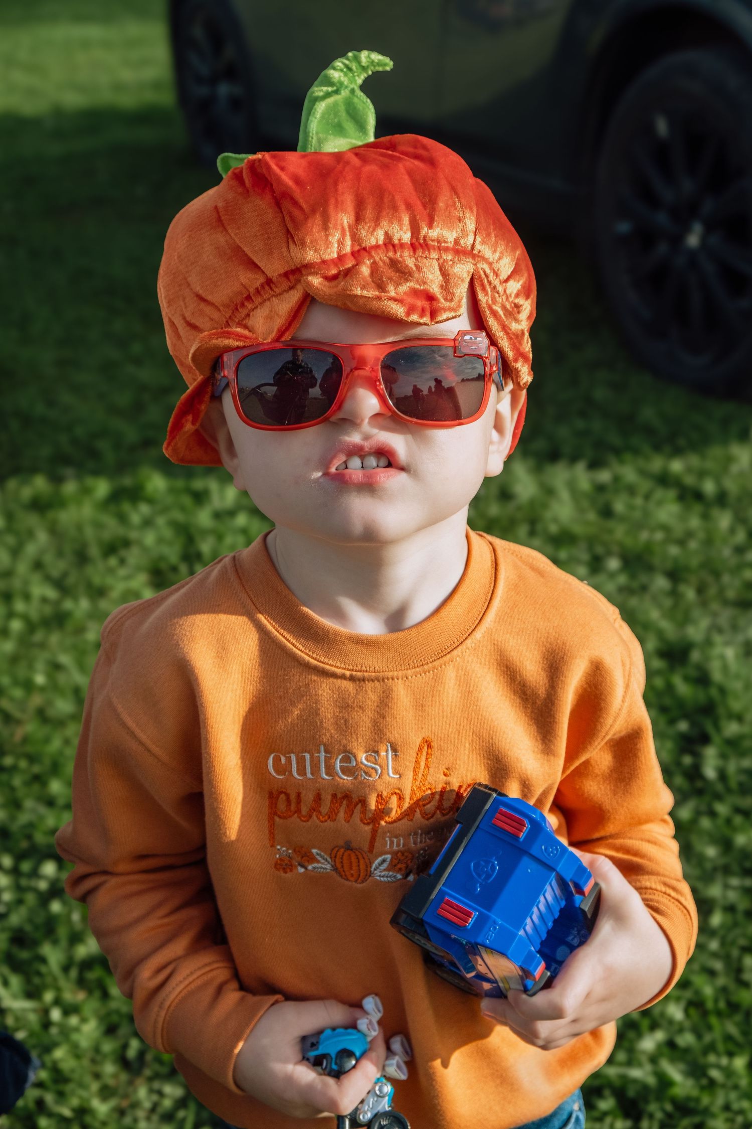 Little boy posing at the pumpkin patch during pumpkin picking.