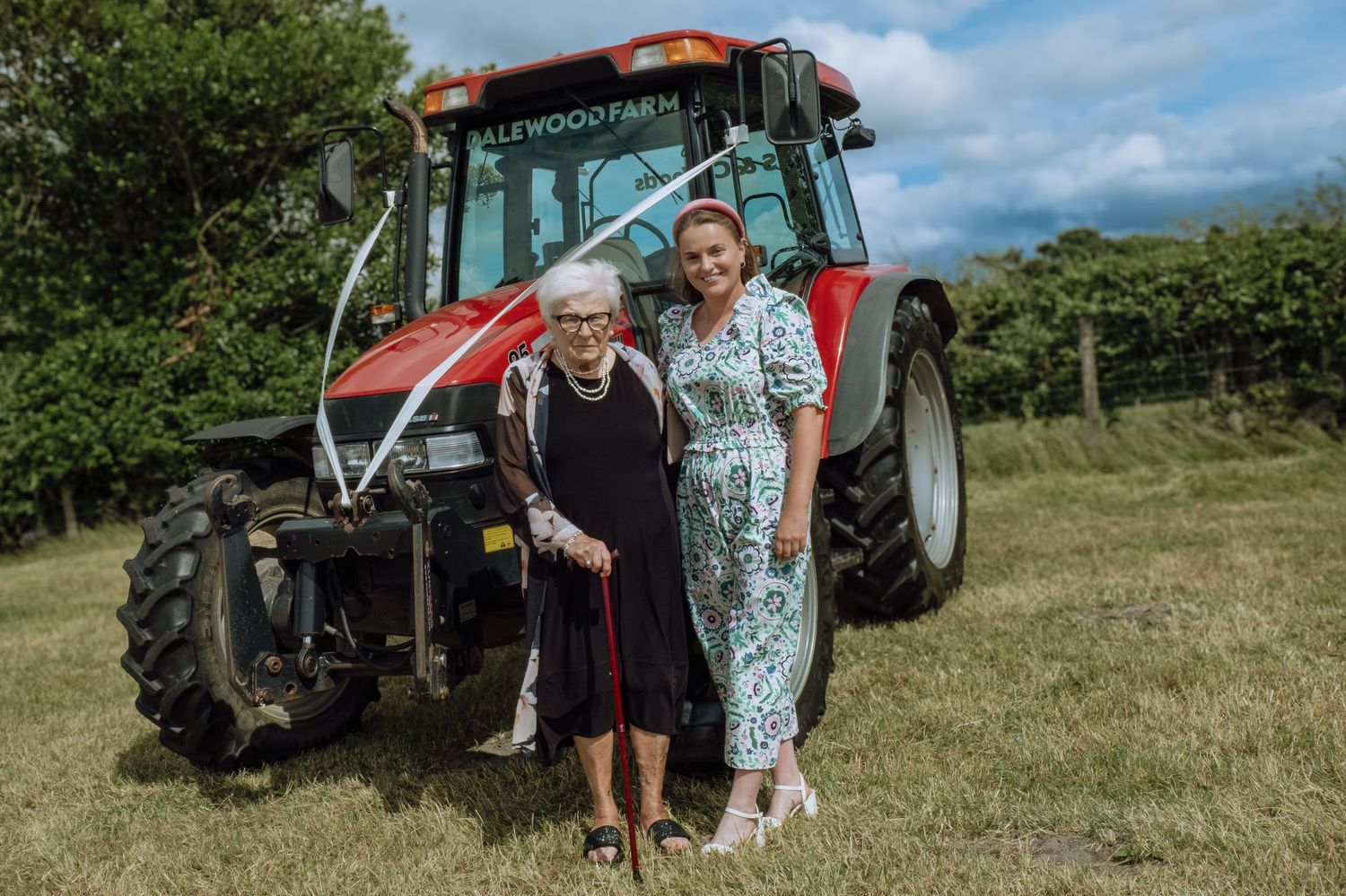 Wedding guest photos in front of the tractor at the wedding reception.