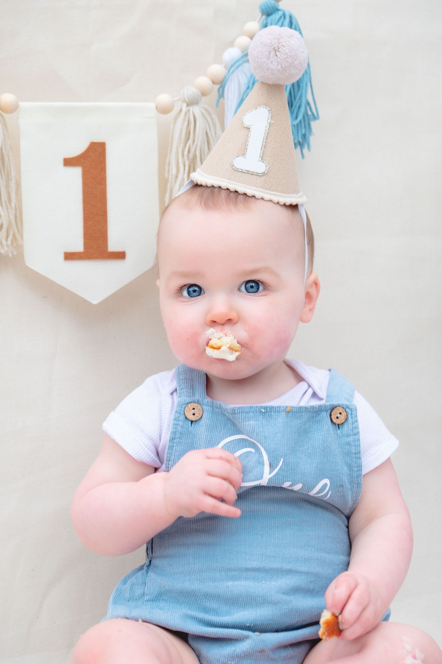 Little boy enjoying his first birthday cake smash photoshoot.