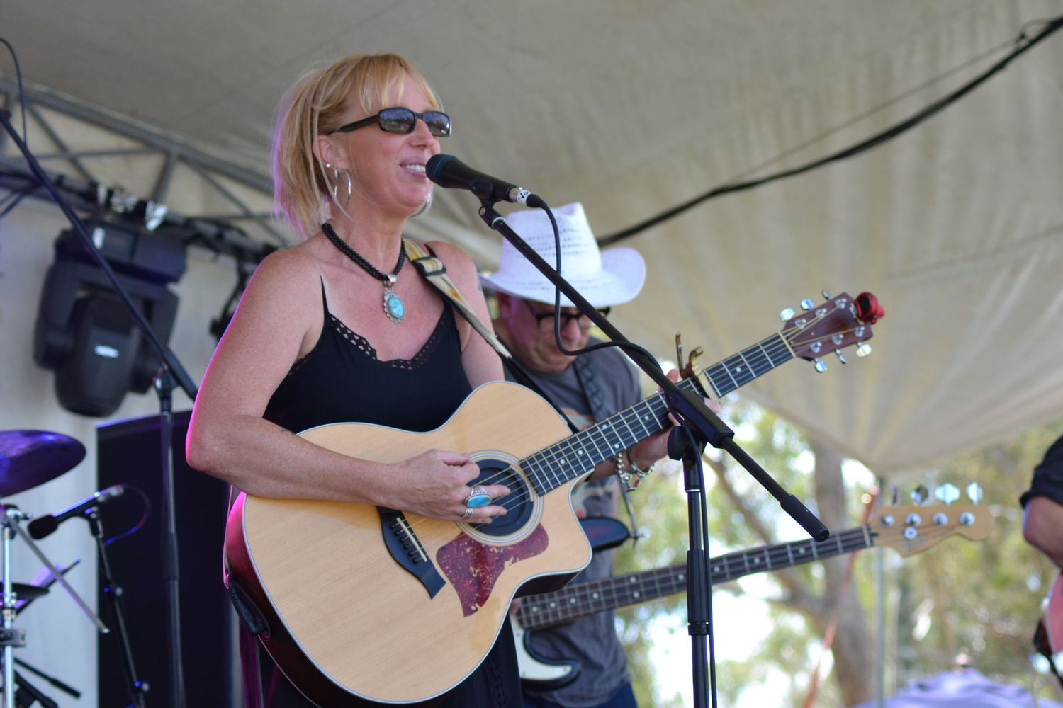 Lady on stage, singing and playing her acoustic guitar on stage at Boyup Brook Country Music Festival in Western Australia.