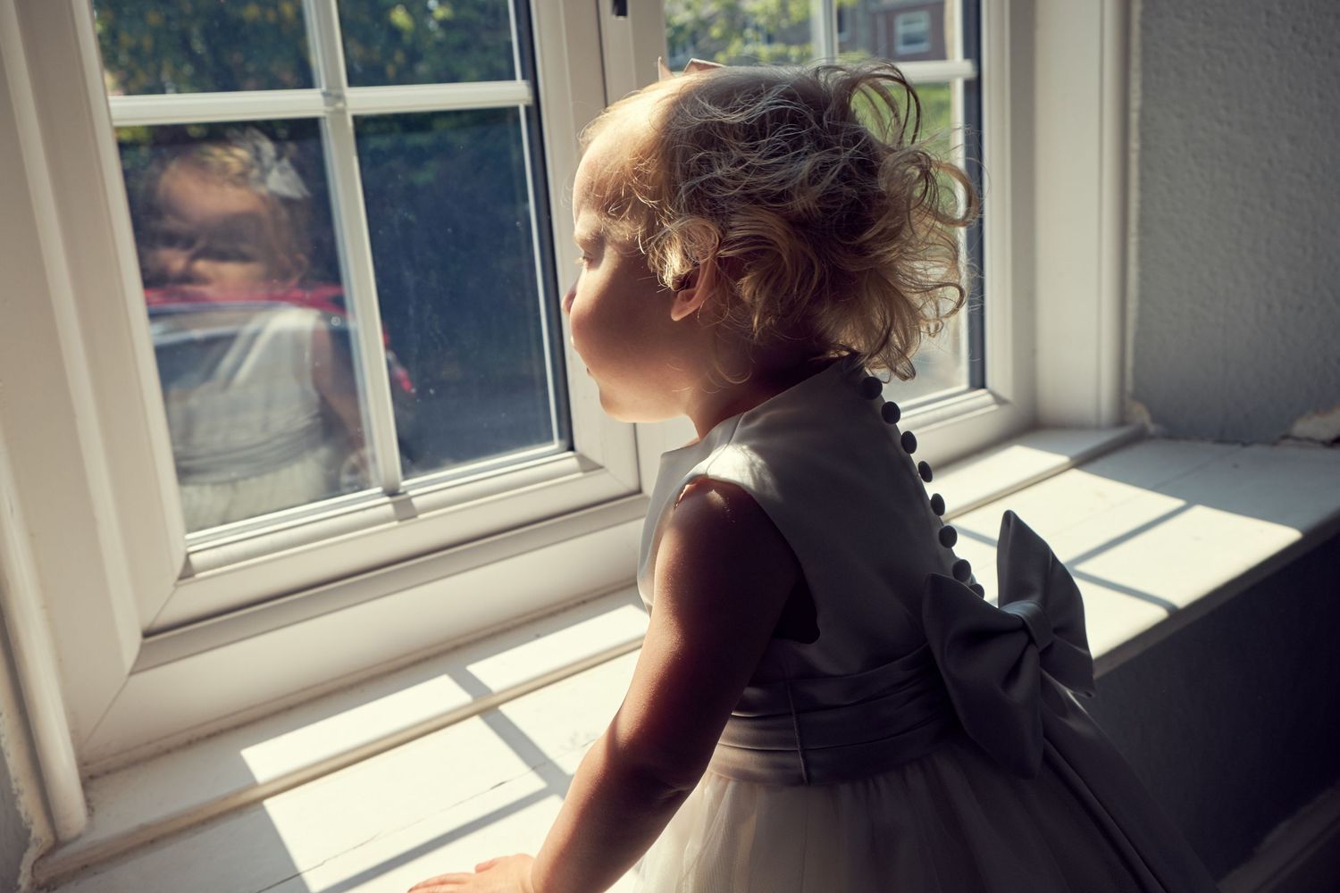 Flower Girl posing looking out the window.