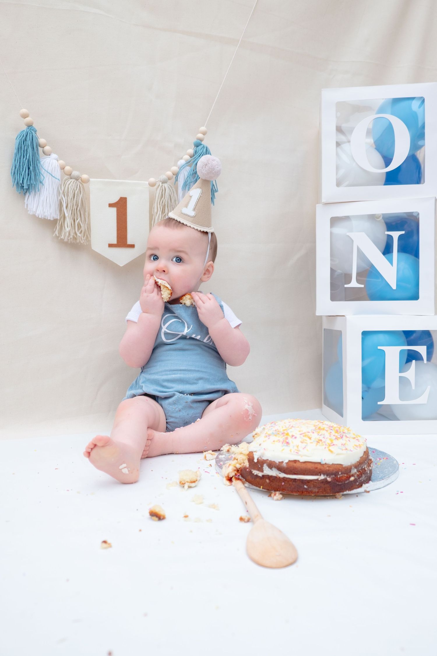 Little boy enjoying his first birthday cake smash photoshoot.