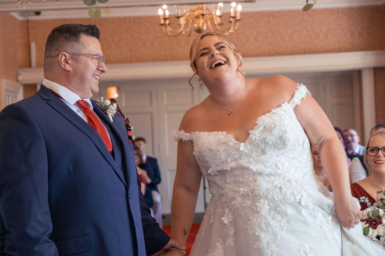 Bride laughing with the groom at the alter of the wedding ceremony.