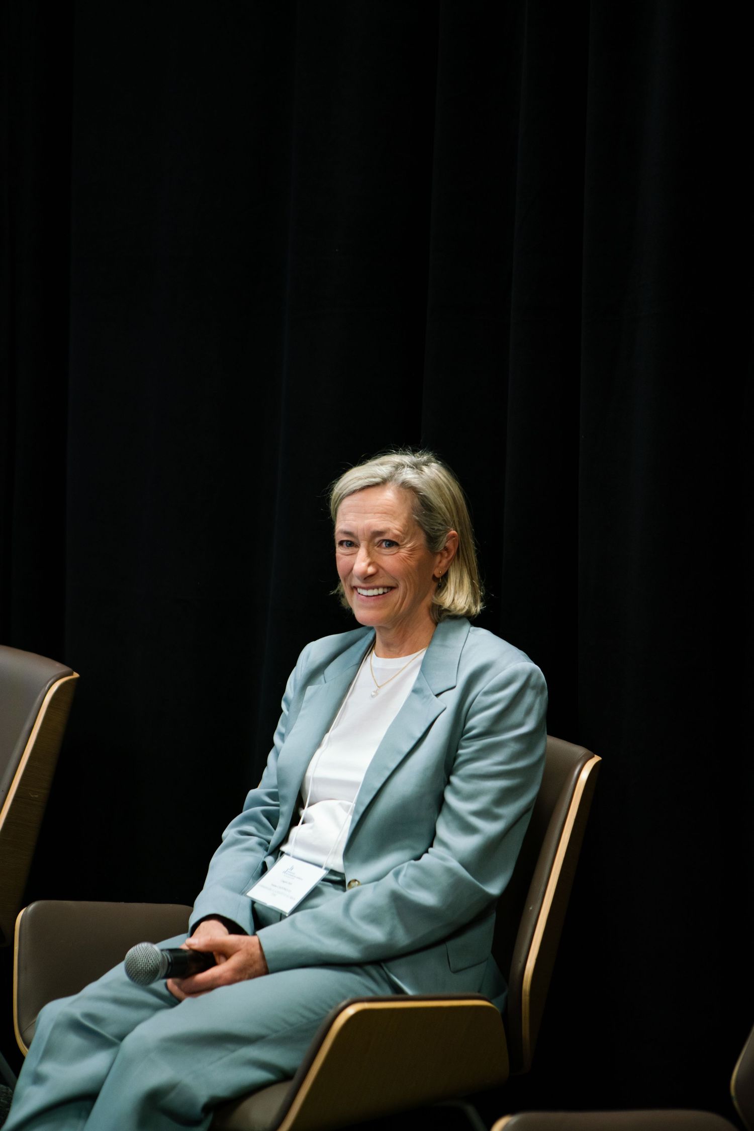 Panelist seated on stage during a conference discussion, event photography by HAMIDI Photography.