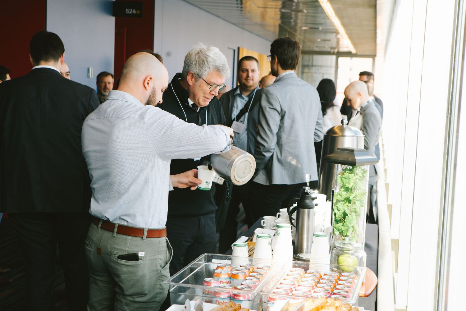 Guests mingling at a corporate reception buffet, event photography by HAMIDI Photography.