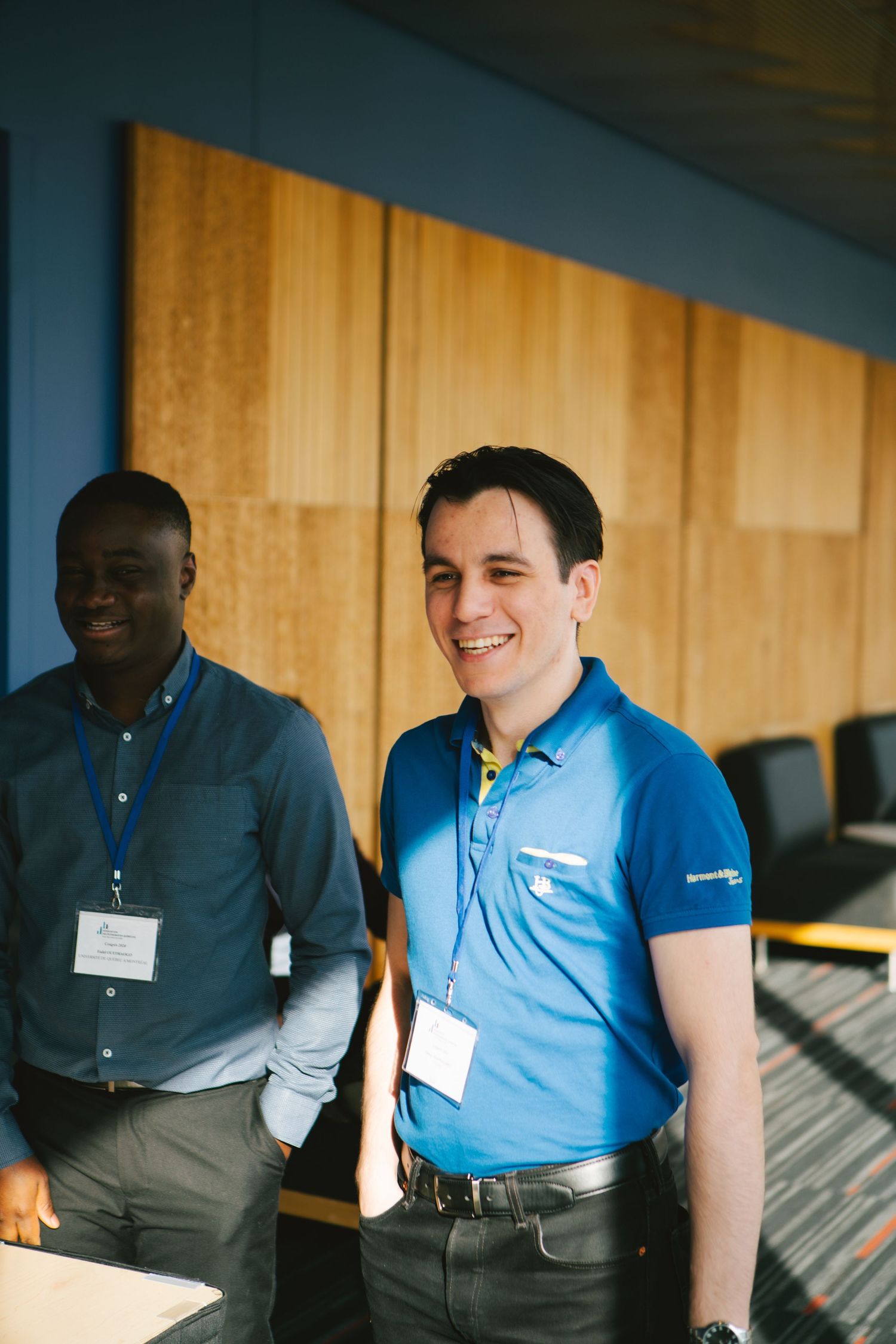 Businesswoman in a blue shirt engaging with colleagues at a corporate event, photography by HAMIDI Photography.