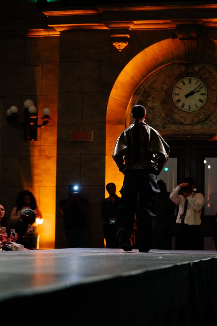 Fashion show venue with warm ambient lighting and architectural arches, event photography by HAMIDI Photography.