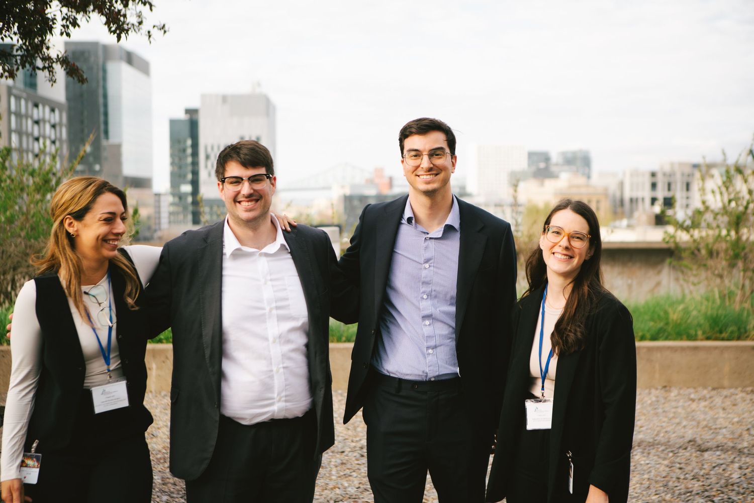 Four business colleagues posing together outdoors at a conference, corporate event photography by HAMIDI Photography.