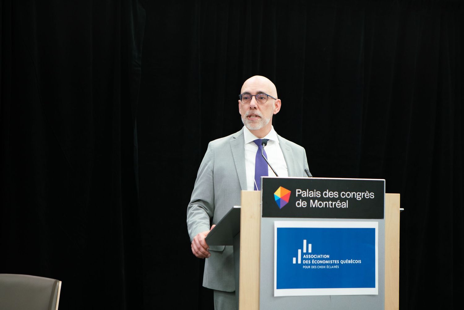 Speaker presenting at a podium during a corporate conference, event photography by HAMIDI Photography.