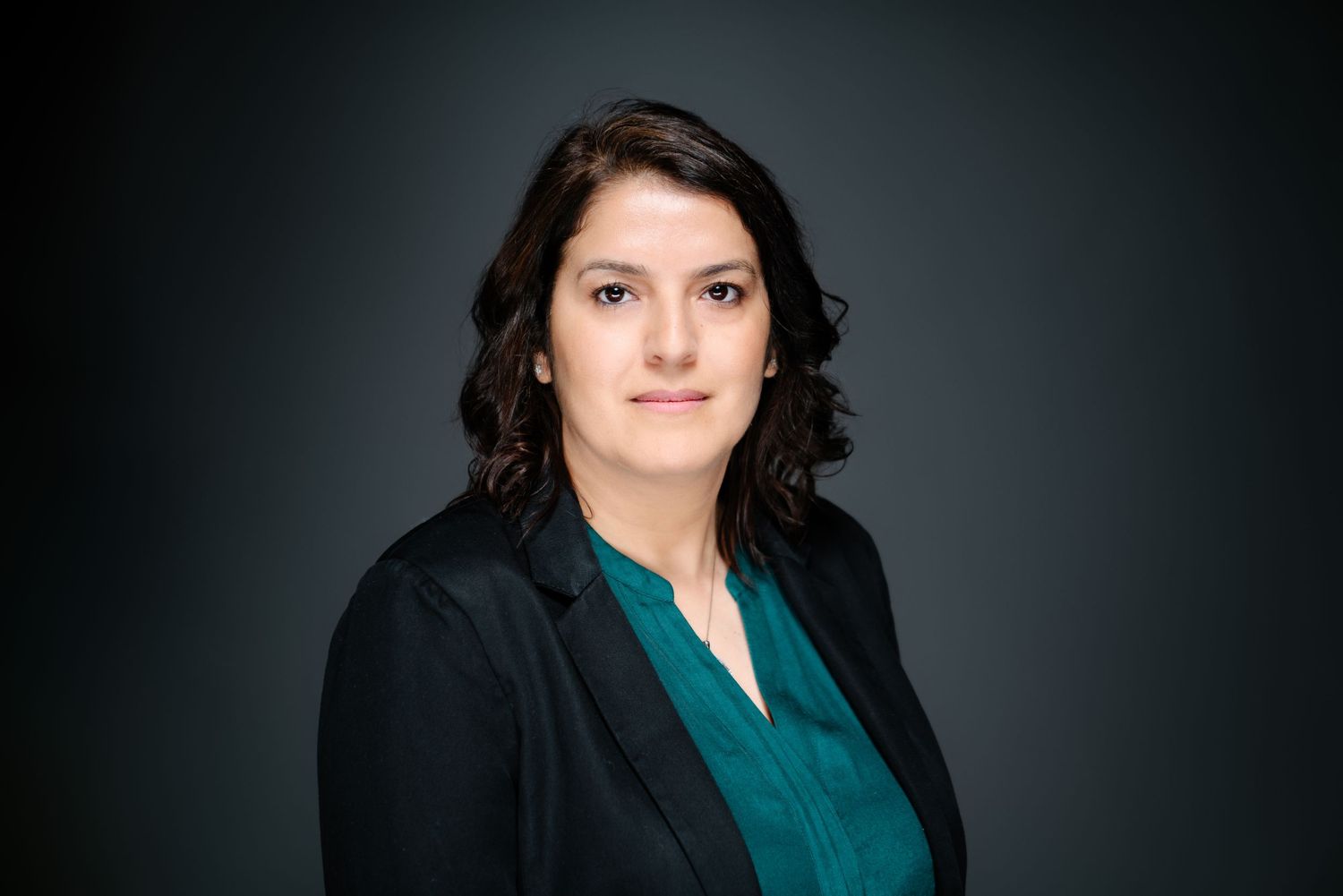 Professional corporate headshot of Fatima against a dark studio backdrop, photography by HAMIDI Photography.