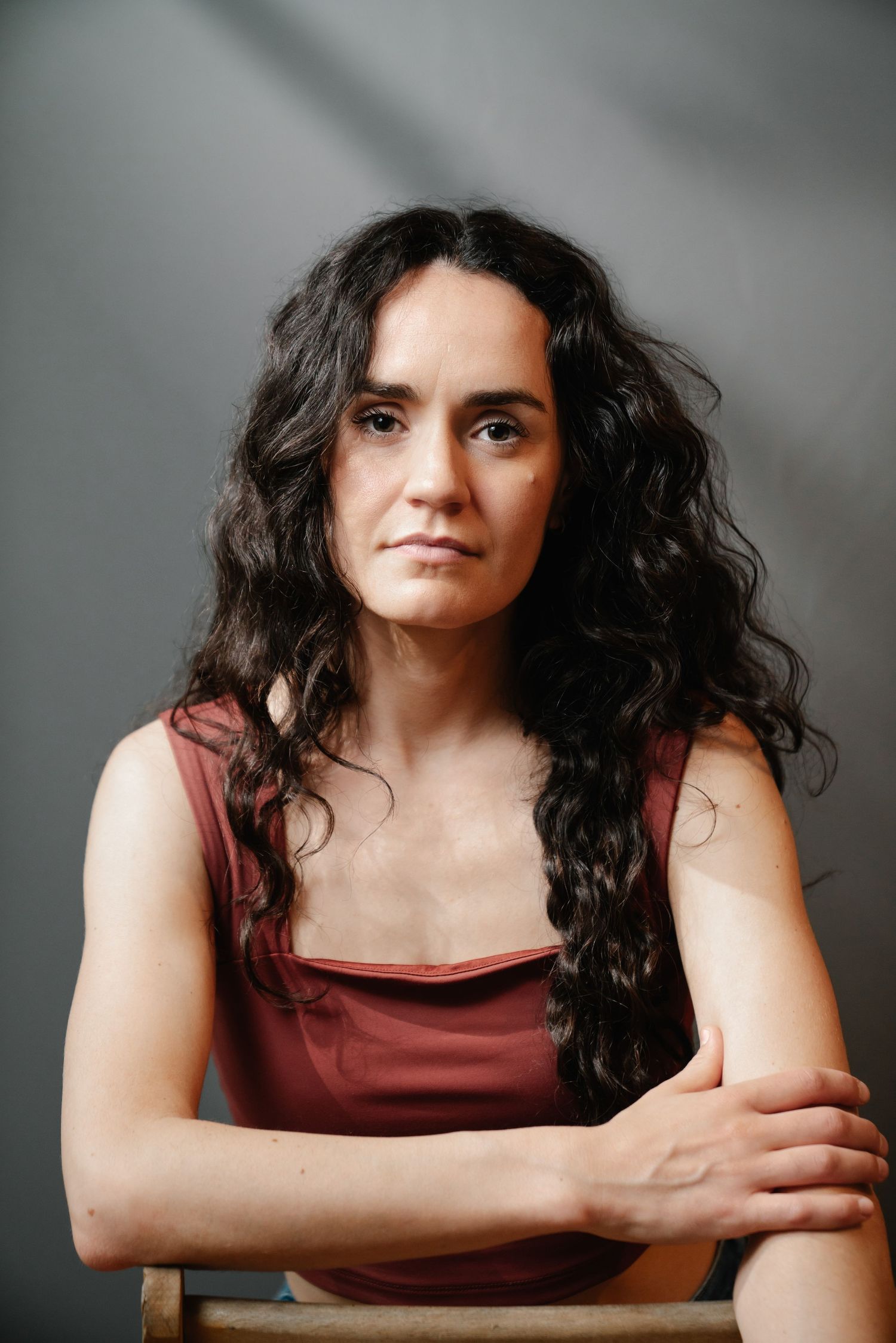 Studio portrait of Virginie against a gray backdrop, photography by HAMIDI Photography.