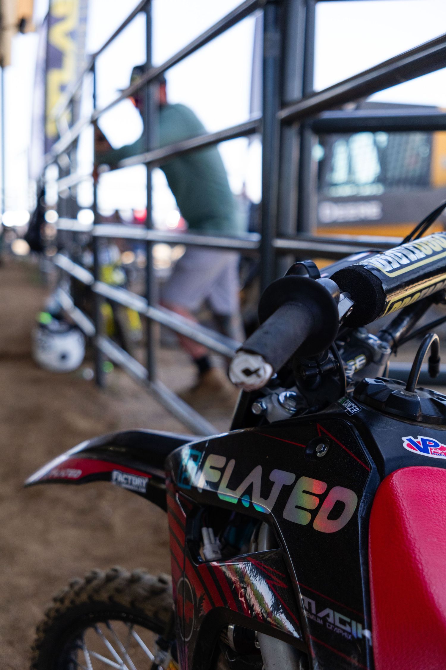 Close-up of a red and black motocross dirt bike with Elated branding at an outdoor racing event.
