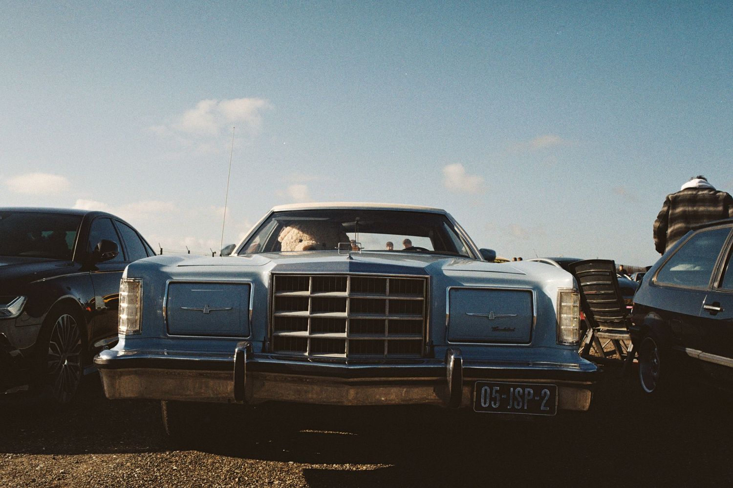 Vintage blue Ford Continental classic car parked outdoors under a clear sky at a car show.