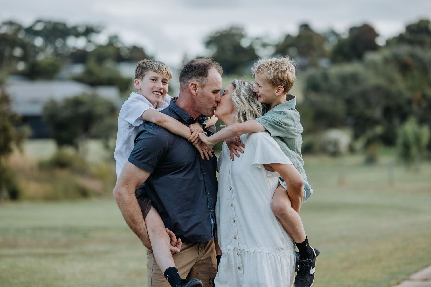 Family sharing joyful moment together outdoors in green field.