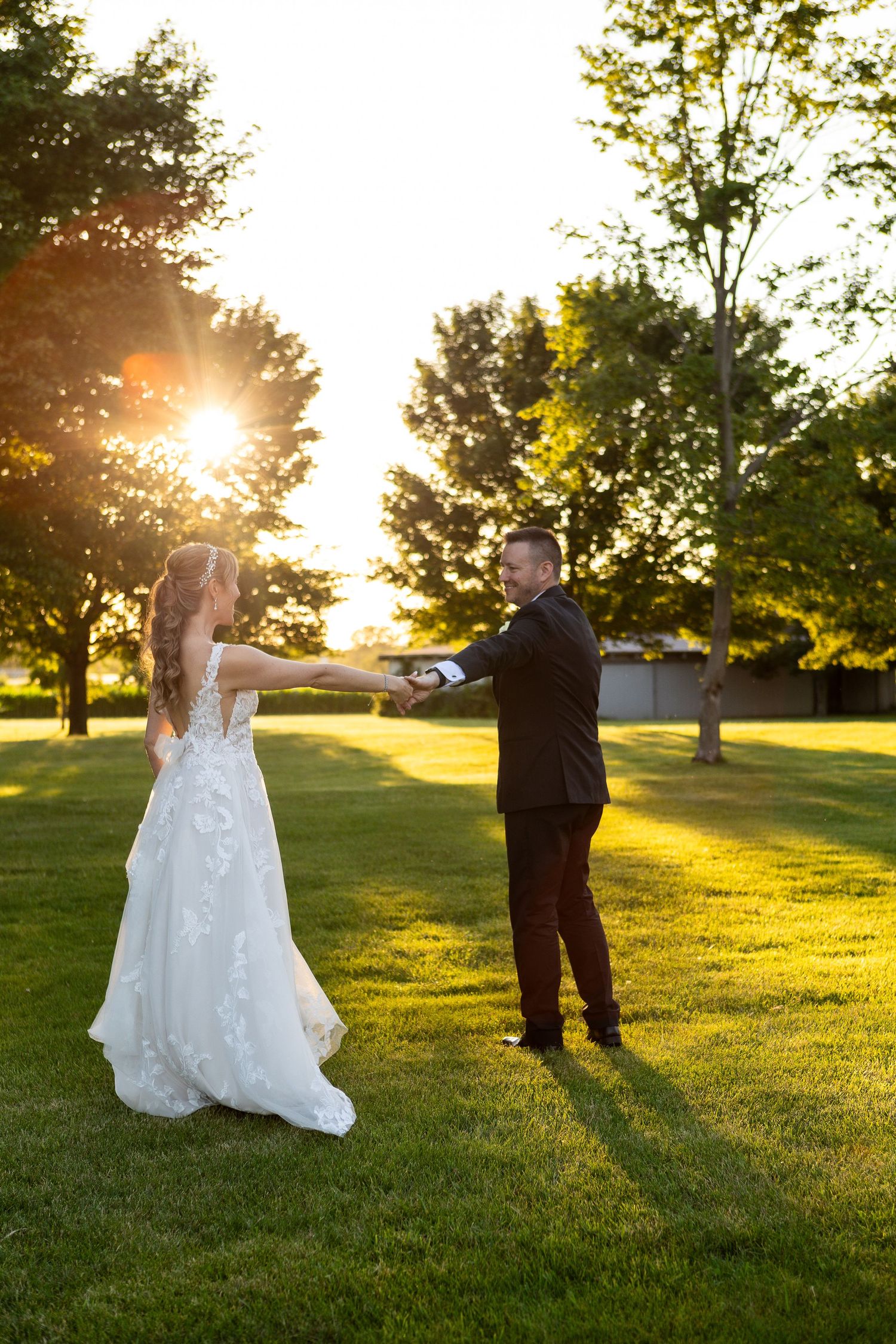 Bride and groom dancing in a sunlit field at golden hour, captured during an outdoor wedding in Illinois by Desert Bloom Photo + Travel Co.