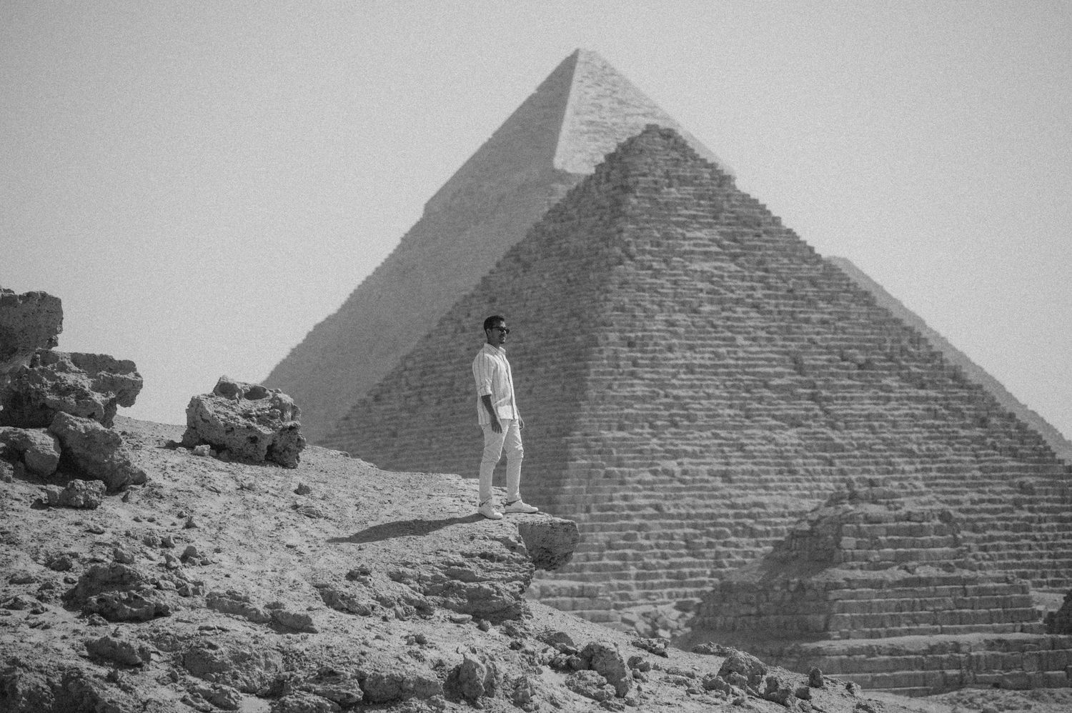 A black and white panoramic view of the Great Pyramids of Giza in Egypt showing multiple angles and perspectives.