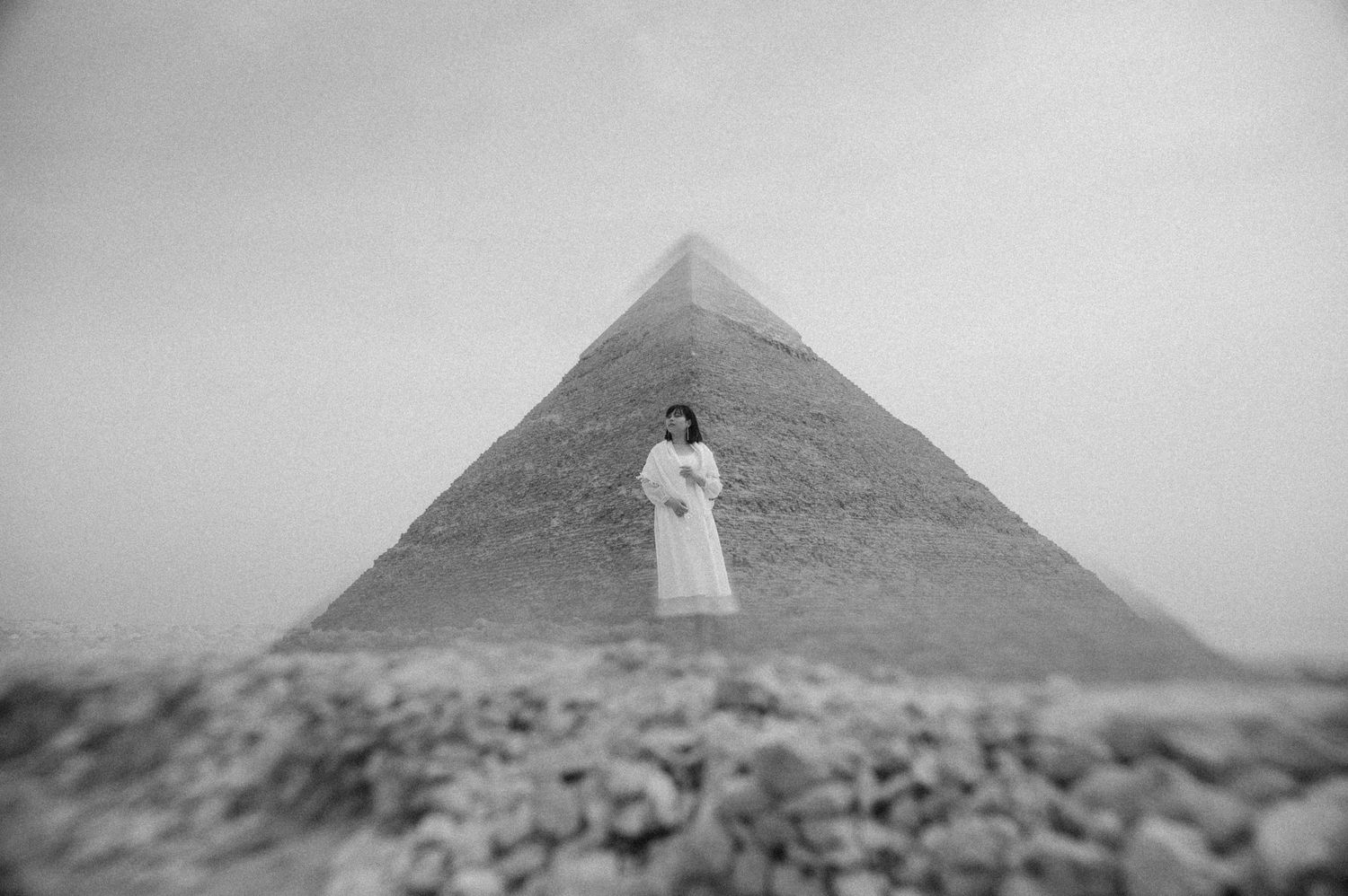 Seven vintage black and white photographs showing different views of the Egyptian pyramids in Giza.