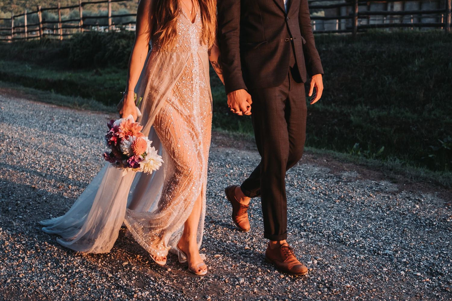 Close-up of wedding couple's feet walking on gravel path.