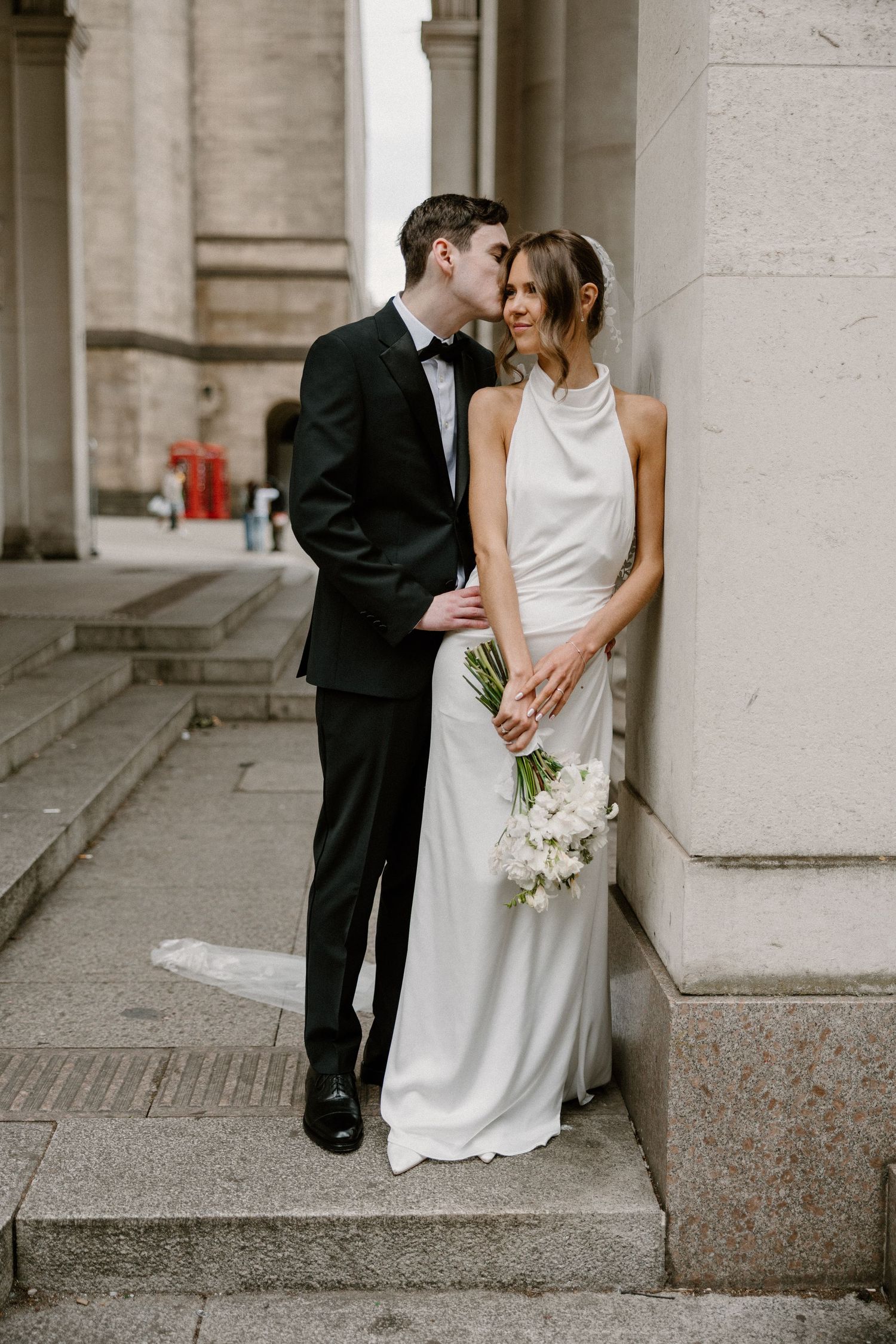 A bride and groom share intimate moments against stone columns in a series of romantic wedding photographs.