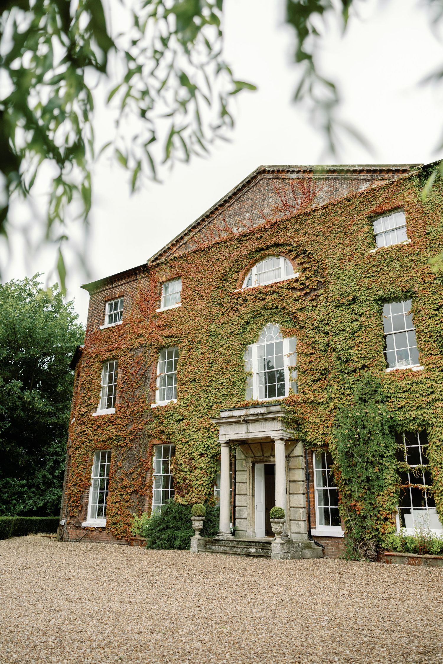 Stately brick mansion with ivy-covered walls and classic Georgian architecture.