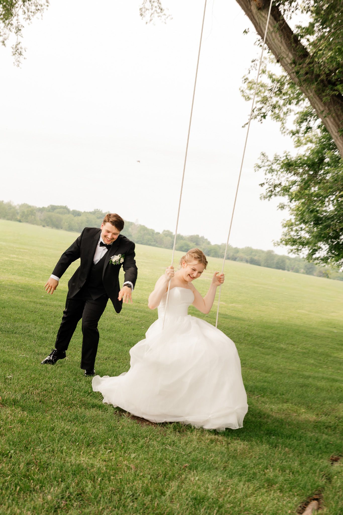 Romantic outdoor wedding photo of couple on a tree swing in Brighton, Michigan.