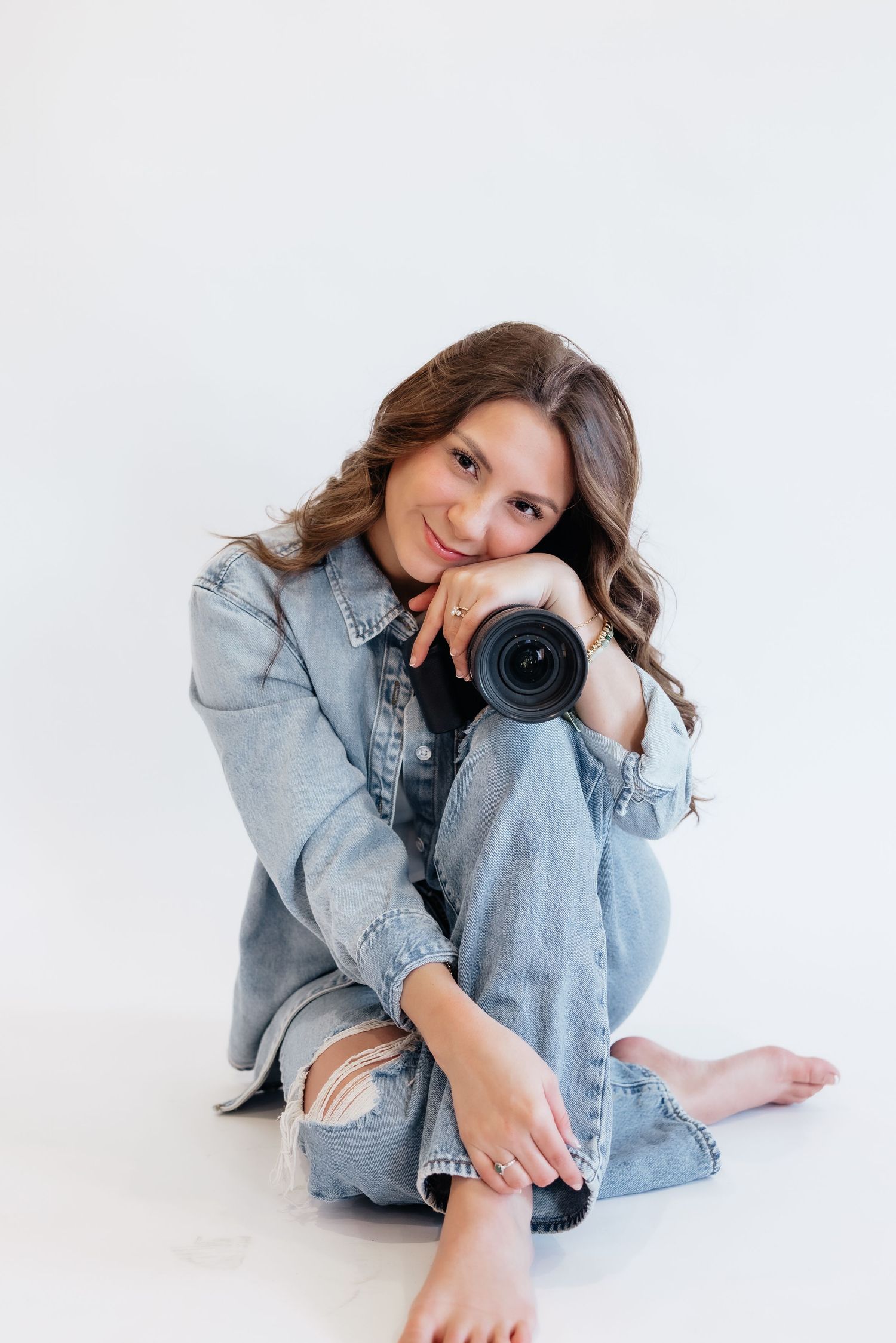 Brena B Imagery Howell, Michigan senior and wedding photographer wearing denim in photography branding session posing with white back drop.