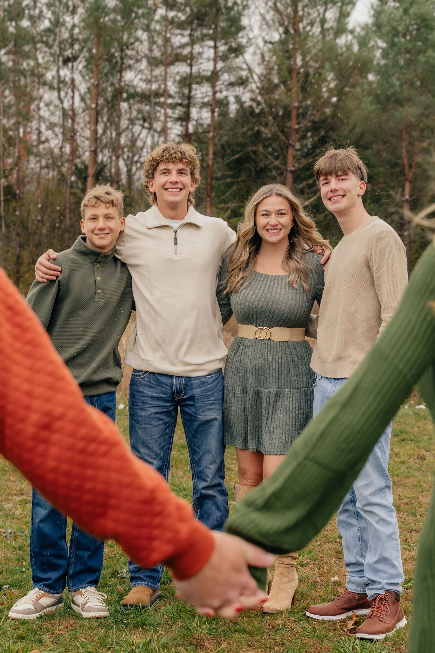 Family portrait session in Fenton, MI featuring parents and adult children, photographed by Brena B Imagery. Parents holding hands.
