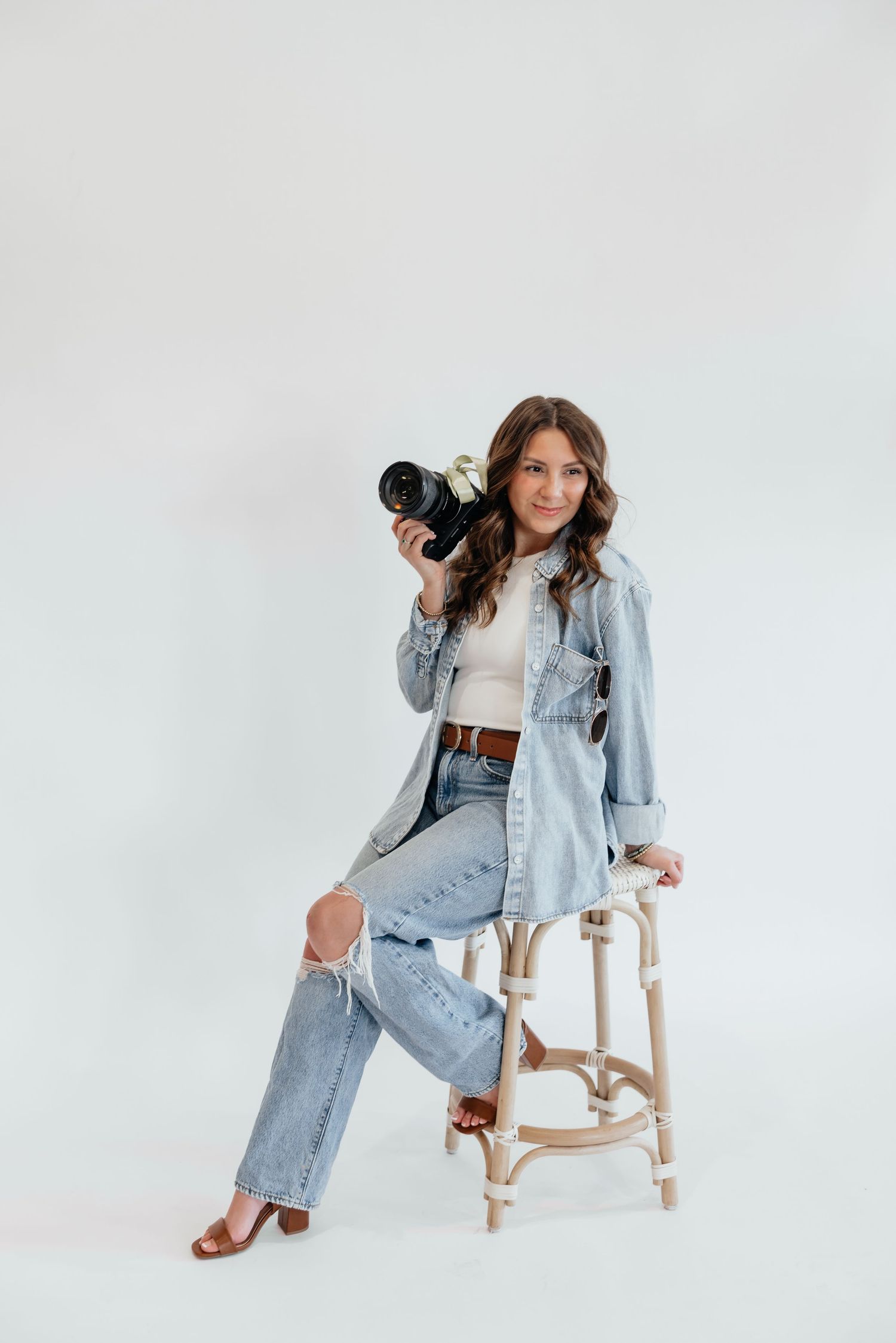 Brena B Imagery Howell, Michigan senior and wedding photographer wearing denim in photography branding session posing on a stool.