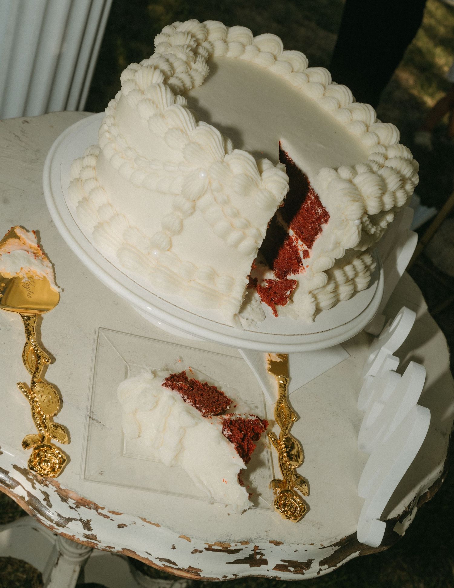 A sequence showing a white wedding cake being sliced to reveal red velvet layers inside.