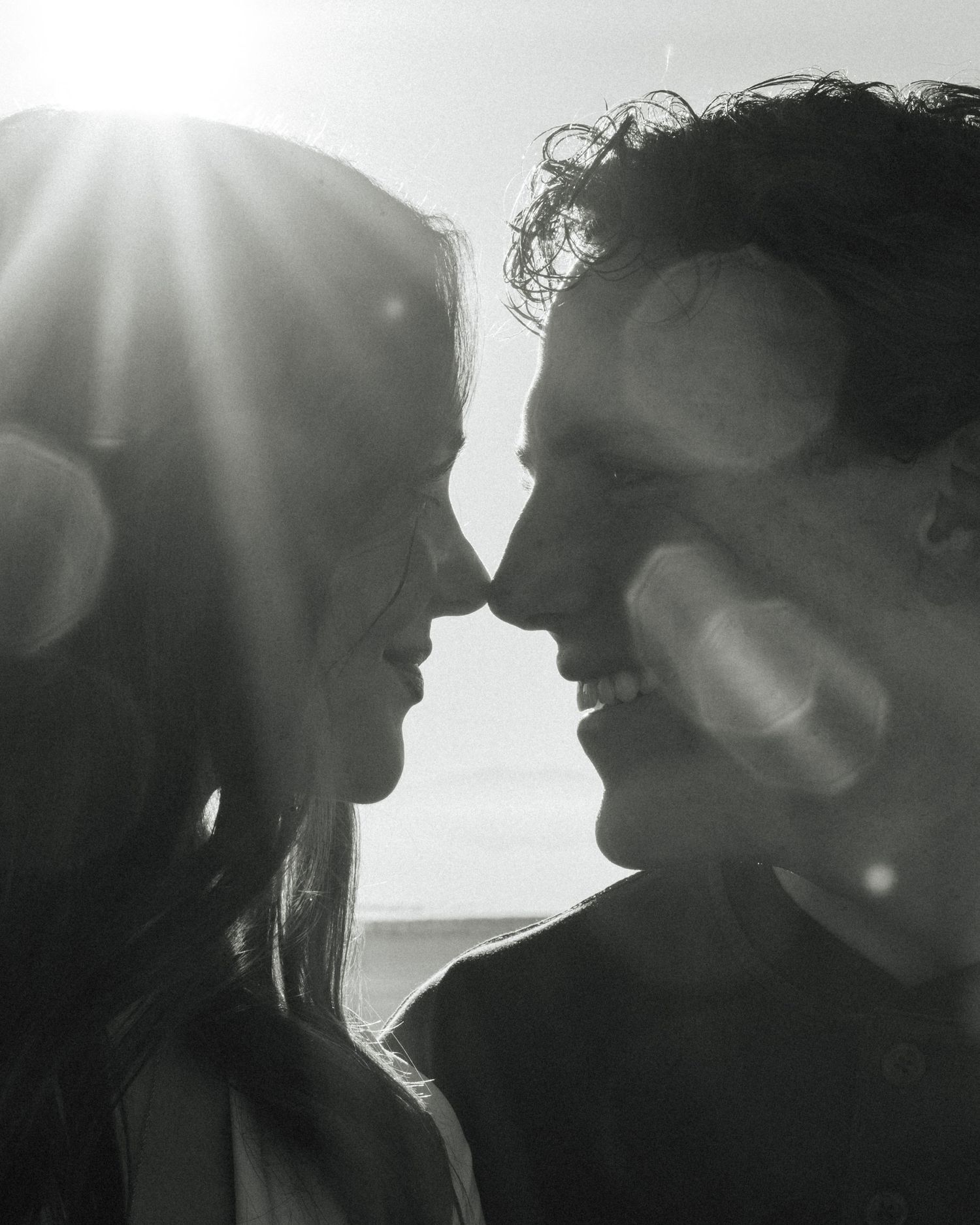 A series of silhouetted figures in profile against a bright background creating a romantic, dreamy atmosphere.