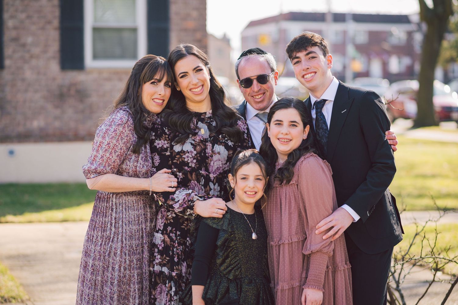 Group photo session with people wearing coordinated mauve and dark colored outfits.