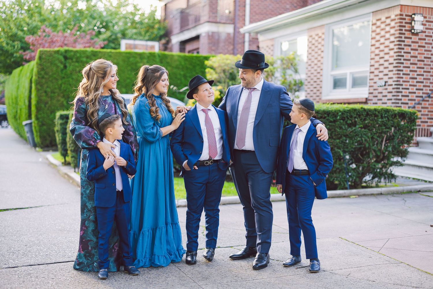 Jewish family in coordinated blue outfits posing outdoors, celebrating a special occasion together.