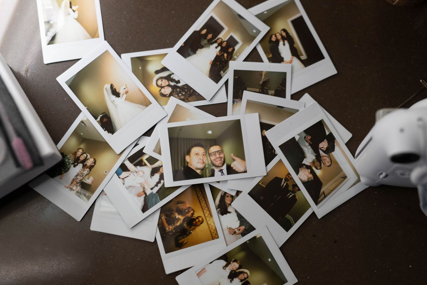 A collection of vintage-style Polaroid photographs scattered on a dark surface.