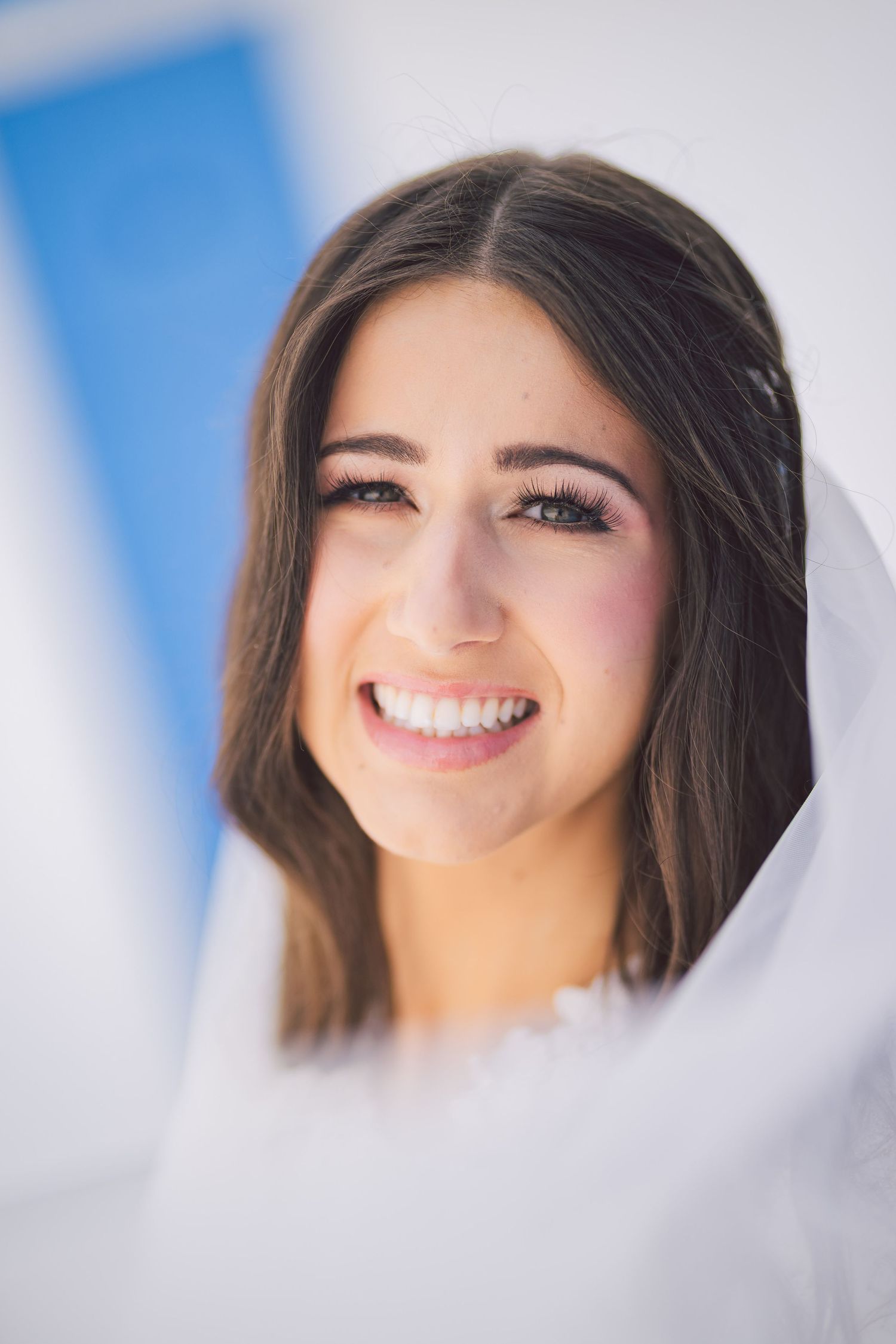 A series of close-up portrait shots showing bright smiles and natural expressions against a blue background.
