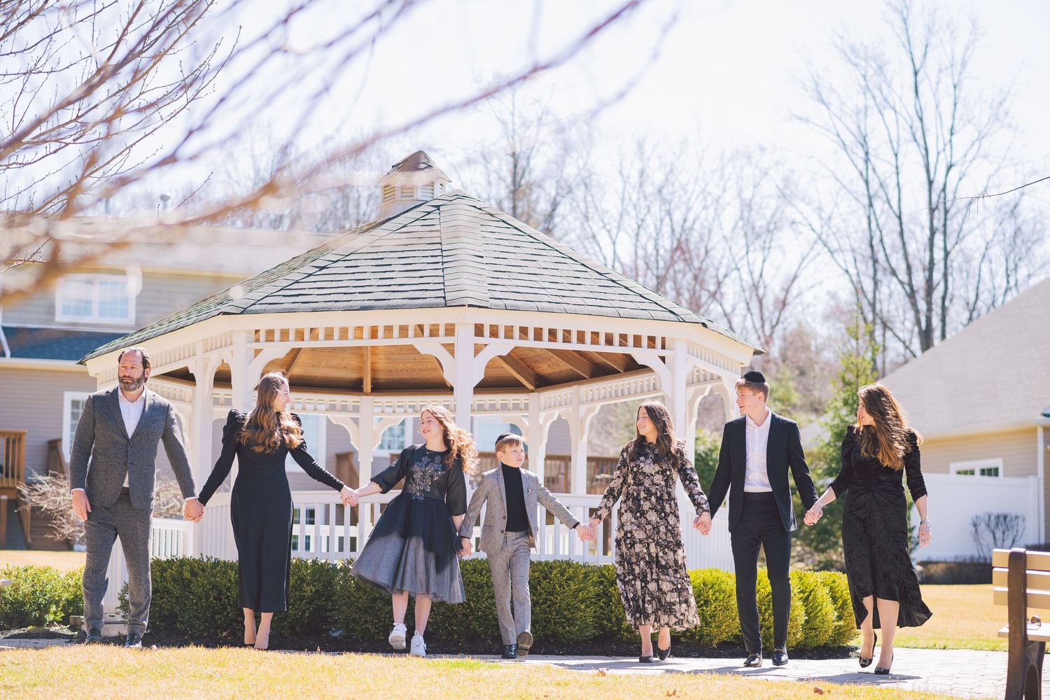 Outdoor group portraits arranged in front of a suburban house with white columns.