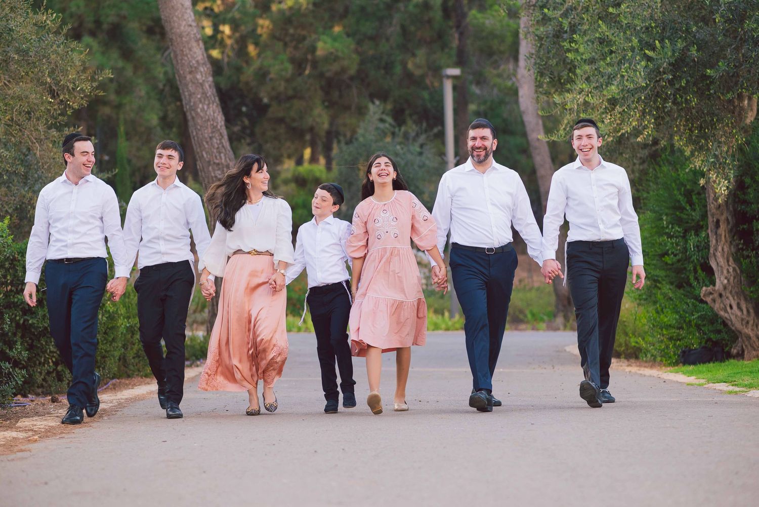 Group walking together along a tree-lined path during an outdoor photo session.
