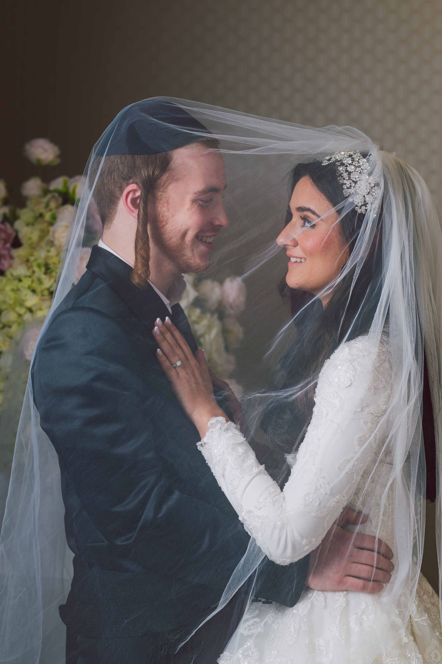 Romantic wedding moment captured through delicate veil.