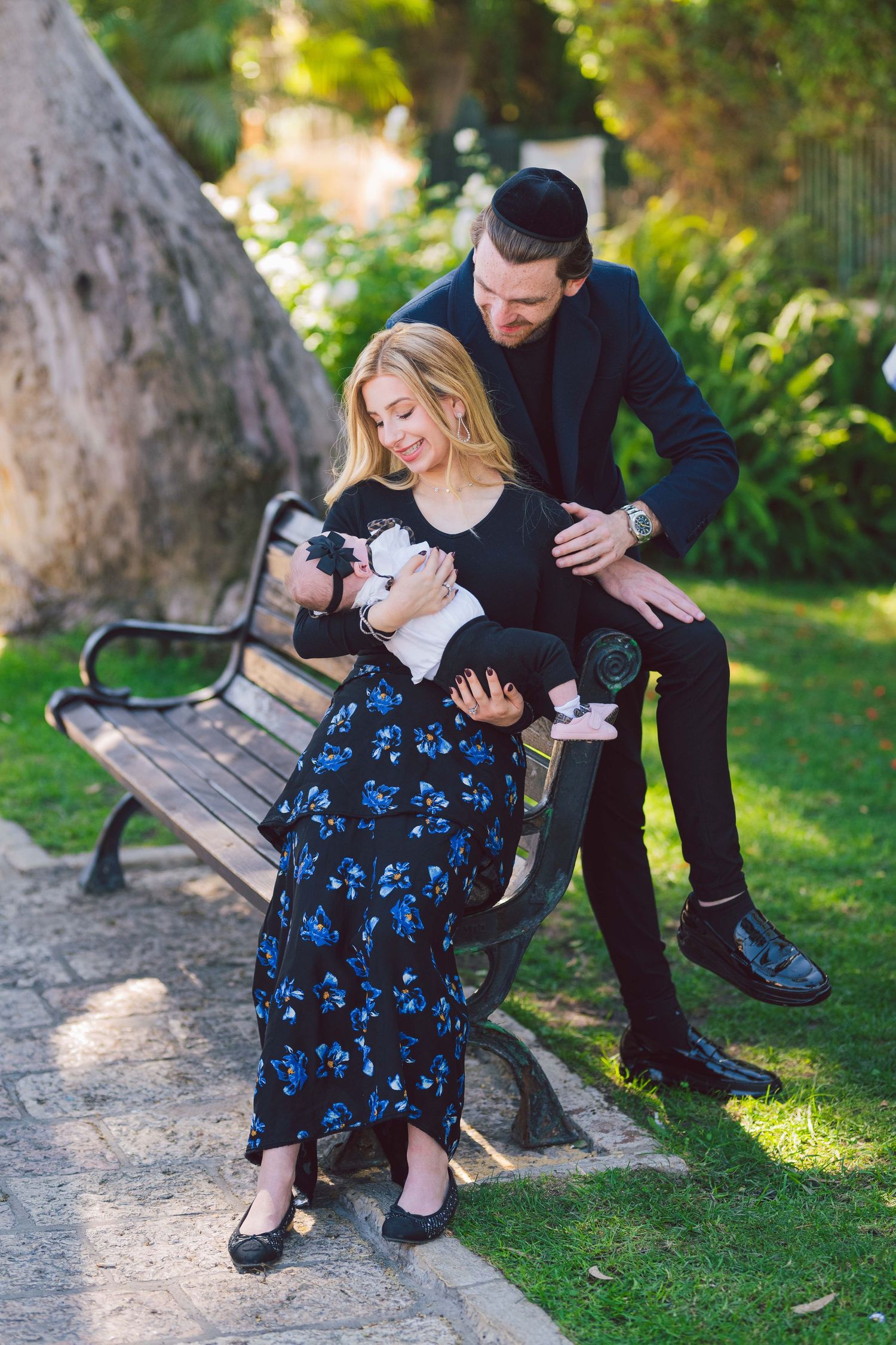 Couple sharing romantic moments on a park bench surrounded by lush greenery.