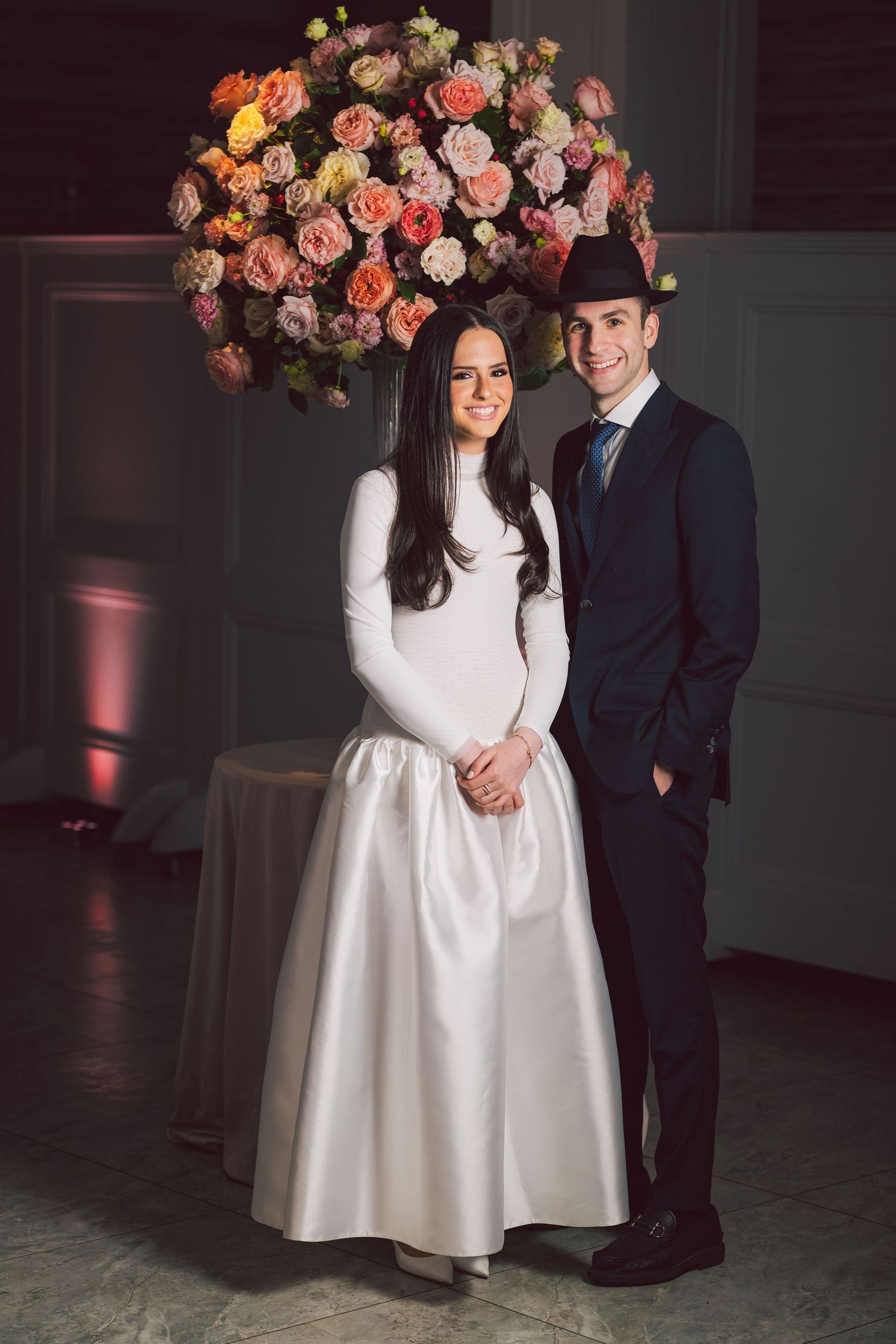 Indoor engagement portraits with beautiful floral arrangements and dramatic lighting.