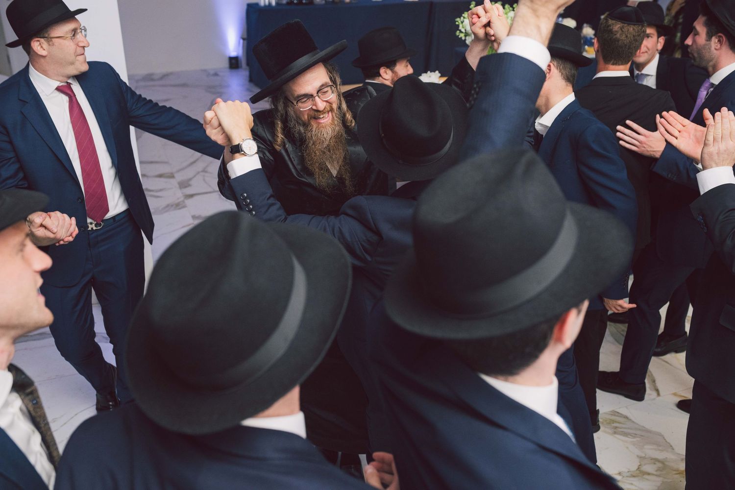 Religious celebration gathering with men wearing traditional black hats.