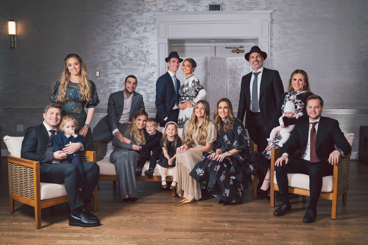 Group portrait in formal attire sitting together in a modern indoor setting.